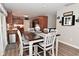 View of dining area with wood floors, farm-style table with seating and views into the kitchen at 1744 Salina Dr, Avon, IN 46123