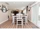 View of dining area with wood floors, farm-style table with seating and views into the living room at 1744 Salina Dr, Avon, IN 46123