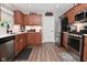 Kitchen features stainless appliances, light countertops, wood cabinets, and hardwood style floors at 1744 Salina Dr, Avon, IN 46123