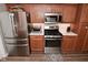 View of stainless appliances, light countertops, wood cabinets, and hardwood style floors in kitchen at 1744 Salina Dr, Avon, IN 46123