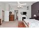 A cozy main bedroom featuring a ceiling fan, fireplace, and neutral carpeting at 1744 Salina Dr, Avon, IN 46123