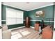 Office space with green accent wall, natural light, and hardwood style floors at 1744 Salina Dr, Avon, IN 46123
