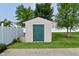 A backyard storage shed with a green door and beige siding, set on a well-manicured lawn at 1744 Salina Dr, Avon, IN 46123