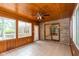 Cozy sunroom featuring wood paneling, brick accent wall, and ample natural light at 180 Hollowview Dr, Noblesville, IN 46060