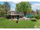 Well-manicured backyard showing patios, ample seating, and a two-story building with a wooden deck on the second floor at 1810 S Raceway Rd, Indianapolis, IN 46231