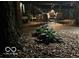 Nighttime scene of a backyard with decorative rock, a fence, and glimpses of outdoor seating at 1810 S Raceway Rd, Indianapolis, IN 46231