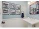 Charming powder room with a pedestal sink, unique mirror, and decorative black and white wall art at 1810 S Raceway Rd, Indianapolis, IN 46231