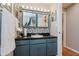 Well-lit powder room with a vessel sink, dark countertop, and ample storage at 1810 S Raceway Rd, Indianapolis, IN 46231