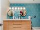 Stylish bathroom with a modern wood vanity, dual round mirrors, and eye-catching geometric tile backsplash at 1810 S Raceway Rd, Indianapolis, IN 46231