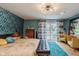 Stylish bedroom with retro wallpaper, wood flooring, and a seating area with plush yellow chairs at 1810 S Raceway Rd, Indianapolis, IN 46231