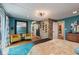 Stylish bedroom with retro wallpaper, wood flooring, stone accent wall, and bright yellow chairs at 1810 S Raceway Rd, Indianapolis, IN 46231