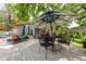 Outdoor patio featuring a shade umbrella, outdoor seating, and a glimpse of the building's architecture at 1810 S Raceway Rd, Indianapolis, IN 46231