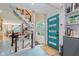 Bright entryway with an updated teal door, modern staircase, and stylish geometric tile flooring at 1810 S Raceway Rd, Indianapolis, IN 46231