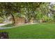 Expansive front yard with mature trees and stone facade house, features a lush lawn and inviting atmosphere at 1810 S Raceway Rd, Indianapolis, IN 46231