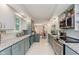 Bright, updated kitchen features granite countertops, stainless steel appliances, and white tile flooring at 1810 S Raceway Rd, Indianapolis, IN 46231