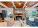 Elegant living room featuring a stone fireplace, wood ceiling, and an open layout connecting to the kitchen at 1810 S Raceway Rd, Indianapolis, IN 46231