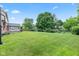 Large backyard featuring a lush green lawn, mature trees, and established landscaping at 1826 Spruce Dr, Carmel, IN 46033
