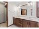 Primary bathroom features dual sinks, wood cabinets, large mirror, and modern lighting at 1826 Spruce Dr, Carmel, IN 46033