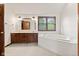 Primary bathroom showcasing dual sinks, wood cabinets, large tub, and a window at 1826 Spruce Dr, Carmel, IN 46033