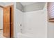 Bright bathroom featuring a white tiled tub, grey walls, and a wood door frame at 1826 Spruce Dr, Carmel, IN 46033