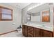 Gray bathroom with tile floor, wooden vanity, window, and good lighting at 1826 Spruce Dr, Carmel, IN 46033