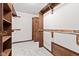 Walk-in closet with neutral carpet, white walls, wooden shelves, hanging racks, and wood trim at 1826 Spruce Dr, Carmel, IN 46033