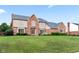 Charming two-story home with a brick facade, manicured lawn, and beautiful landscaping at 1826 Spruce Dr, Carmel, IN 46033