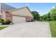 Attached garage and driveway with basketball hoop in the yard at 1826 Spruce Dr, Carmel, IN 46033