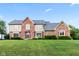 Charming two-story home with a brick facade, manicured lawn, and beautiful landscaping at 1826 Spruce Dr, Carmel, IN 46033
