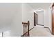 Upstairs hallway with neutral carpet, white walls, and decorative wooden stair railing at 1826 Spruce Dr, Carmel, IN 46033