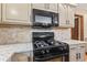 Kitchen featuring modern appliances, granite countertops, tiled backsplash, and sleek gas range at 1826 Spruce Dr, Carmel, IN 46033