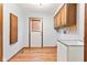 Functional laundry room with utility sink, wood cabinets and access door at 1826 Spruce Dr, Carmel, IN 46033