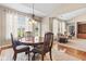 Dining room features a round wooden table, chandelier, and seamless transition to the inviting living area at 18991 Round Lake Rd, Noblesville, IN 46060