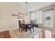 Cozy dining room boasts hardwood floors, elegant chandelier, and ample natural light from the window at 18991 Round Lake Rd, Noblesville, IN 46060