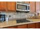 Close-up of a modern kitchen with granite countertops, stainless steel microwave, and sleek cooktop at 18991 Round Lake Rd, Noblesville, IN 46060