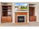 Living room with a built-in fireplace and cabinetry and a TV mounted above the mantel at 18991 Round Lake Rd, Noblesville, IN 46060