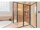 Tiled shower features a glass door, built-in shelving, and modern fixtures at 18991 Round Lake Rd, Noblesville, IN 46060