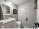 Bathroom featuring a grey vanity, toilet, mirror, with grey walls and modern decor at 20417 State Road 37 N, Noblesville, IN 46060