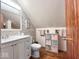 Bathroom with light grey vanity, white toilet, wood floors and grey and pink decor at 20417 State Road 37 N, Noblesville, IN 46060