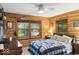 Cozy bedroom with wood paneled walls, comfortable furnishings, and picturesque outdoor views at 20417 State Road 37 N, Noblesville, IN 46060