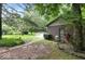 Exterior shot of a garage with a green door surrounded by lush greenery and mature trees at 20417 State Road 37 N, Noblesville, IN 46060