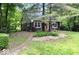 Charming log cabin with a red door surrounded by a lush green yard and mature trees at 20417 State Road 37 N, Noblesville, IN 46060