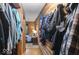 Hallway featuring wood-paneled walls and a view into a bedroom, with a convenient coat rack showcasing various jackets and bags at 20417 State Road 37 N, Noblesville, IN 46060
