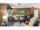 The comfortable living room features a stone fireplace, wood paneled walls, and ample natural light at 20417 State Road 37 N, Noblesville, IN 46060