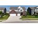 Two-story home with a two-car garage, brick accents, light gray siding, and a nicely landscaped front yard at 2358 S Stonehill Way, New Palestine, IN 46163