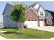Two-story home with brick accents, light gray siding, a two-car garage, and a well-manicured front yard at 2358 S Stonehill Way, New Palestine, IN 46163