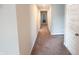 Well-lit hallway with neutral paint, carpet, and doors leading to bedrooms and other areas of the home at 2358 S Stonehill Way, New Palestine, IN 46163