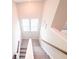 Staircase leading downstairs with carpet steps and a wooden handrail, offering a safe transition at 2358 S Stonehill Way, New Palestine, IN 46163