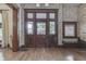 Classic entryway showcasing a beautiful wooden door with decorative glass panels and original hardwood floors at 250 N Home Ave, Franklin, IN 46131