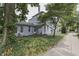 Quaint two-story home with a blue brick exterior, charming front yard, and mature trees at 250 N Home Ave, Franklin, IN 46131